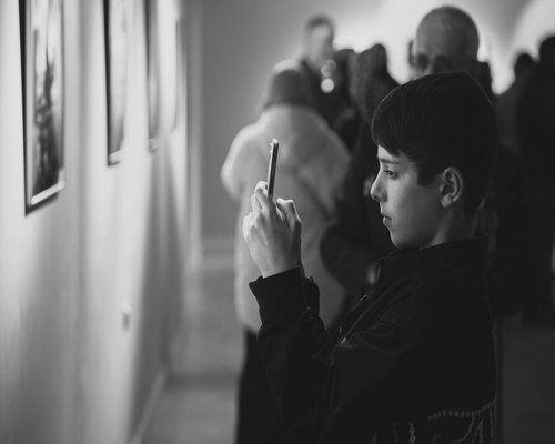 Visitors exploring smartphones and gaming technology at an exhibition